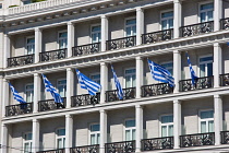 Greece, Attica, Athens, Greek flags flying on building near the parliament.