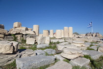 Greece, Attica, Athens, Acropolis ruins with tourists and large Greek flag.