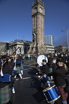 Ireland, North, Belfast, St Patricks Day parade passing the Albert clock on the corner of High Street and Victoria Street.