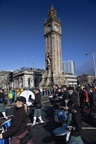 Ireland, North, Belfast, St Patricks Day parade passing the Albert clock on the corner of High Street and Victoria Street.