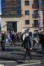 Ireland, North, Belfast, St Patricks Day parade passing the Albert clock on the corner of High Street and Victoria Street.