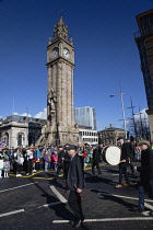 Ireland, North, Belfast, St Patricks Day parade passing the Albert clock on the corner of High Street and Victoria Street.