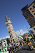 Ireland, North, Belfast, St Patricks Day parade passing the Albert clock on the corner of High Street and Victoria Street.