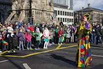 Ireland, North, Belfast, St Patricks Day parade passing the Albert clock on the corner of High Street and Victoria Street.