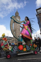 Ireland, North, Belfast, St Patricks Day parade passing the Albert clock on the corner of High Street and Victoria Street.