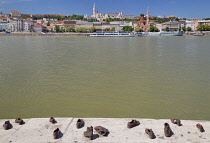 Hungary, Budapest, View across the River Danube to Castle Hill with the Shoes on the Danube Bank memorial in the foreground.