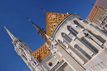 Hungary, Budapest, Matthias Church, Detail of the colourful majolica roof tiles and its tower from the rear of the building.