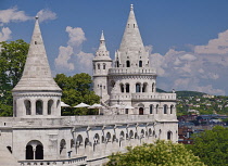 Hungary, Budapest, Castle Hill, Fishermans Bastion, Westernmost towers amidst trees and looking towards the western end of the city.