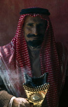 Qatar, General, Bedouin man with incense burning in a traditional container.