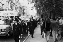 England, London, Gay Pride Parade, Piccadilly, beside Green Park, parade, Metropolitan Police escort, pedestrains, Press photographer.