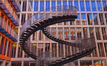 Germany, Bavaria, Munich, The Endless or Infinite Staircase sculpture by Olafur Eliasson with KPMG offices behind..