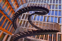 Germany, Bavaria, Munich, Angular view of The Endless or Infinite Staircase sculpture by Olafur Eliasson with KPMG offices behind..