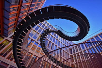 Germany, Bavaria, Munich, Angular view from below of a section of The Endless or Infinite Staircase sculpture by Olafur Eliasson with KPMG offices behind..