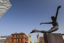 Ireland, North, Belfast, Titanic Quarter, Visitor centre designed by Civic Arts & Eric R Kuhne, with statue of diving woman in foreground.