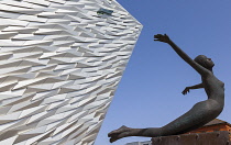 Ireland, North, Belfast, Titanic Quarter, Visitor centre designed by Civic Arts & Eric R Kuhne, with statue of diving woman in foreground.