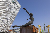 Ireland, North, Belfast, Titanic Quarter, Visitor centre designed by Civic Arts & Eric R Kuhne, with statue of diving woman in foreground.