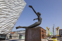 Ireland, North, Belfast, Titanic Quarter, Visitor centre designed by Civic Arts & Eric R Kuhne, with statue of diving woman in foreground.