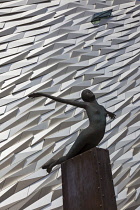 Ireland, North, Belfast, Titanic Quarter, Visitor centre designed by Civic Arts & Eric R Kuhne, with statue of diving woman in foreground.