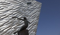 Ireland, North, Belfast, Titanic Quarter, Visitor centre designed by Civic Arts & Eric R Kuhne, with statue of diving woman in foreground.