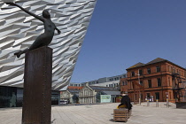 Ireland, North, Belfast, Titanic Quarter, Visitor centre designed by Civic Arts & Eric R Kuhne, with statue of diving woman in foreground.