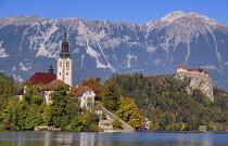 Slovenia, Upper Carniola, Bled, Bled Island and the Church of the Annunciation from the lake shore with Bled Castle in the background.