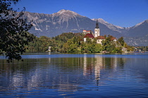 Slovenia, Upper Carniola, Bled, Bled Island and the Church of the Annunciation from the lake shore with Bled Castle in the background.