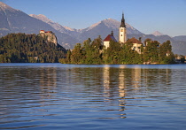 Slovenia, Upper Carniola, Bled, Bled Island and the Church of the Annunciation from the lake shore with Bled Castle in the background.