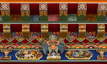 Ornately painted eaves with a Garuda and other Buddhist symbols on a building in Lhasa, Tibet.