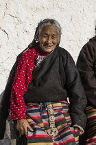 A Khamba Tibetan woman from the Kham region of eastern Tibet on a pilgrimage to visit holy sites in Lhasa, Tibet.  She is wearing her colorful traditional bangdian or pangden apron.