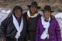 Khamba Tibetan women from the Kham region of eastern Tibet on a pilgrimage to visit the Potala Palace in Lhasa, Tibet.  They have white Buddhist prayer scarves or khatas around their necks.  Felt cowb...