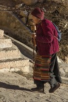 An older Tibetan woman pilgrim with her prayer wheel at the Drepung Monastery near Lhasa, Tibet.