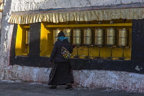 A Tibetan woman turns the prayer wheels at the Drepung Buddhist Monastery near Lhasa, Tibet.
