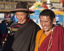 A Tibetan Buddhist pilgrim from the Kham region of eastern Tibet and a monk circumambulating around the Jokhang Temple in Lhasa, Tibet.