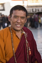 A Tibetan Buddhist monk at the Jokhang Temple in Lhasa, Tibet.  Around his neck are his mala rosary beads.