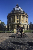 England, Oxford, Bodleian Library, Radcliffe Camera with cyclist passing.