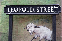 England, Oxford, Cowley Road, road sign and mural detail.