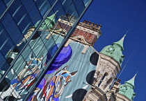 Ireland, County Antrim, Belfast, Towers of the National Bar and Restaurant reflected in  a modern glass building.