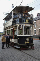 England, County Durham, Beamish, Street with electric tram full of tourists.
