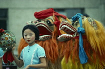 China,  Chinese New Year Dragon dancers and young girl.