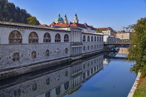 Slovenia, Ljubljana, Plecnik Colonnade and Central Market with the Cathedral of St Nicholas behind and the Ljubljanica River in the foreground.