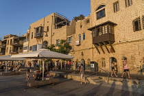 Israel, Jaffa, Old Jaffa, Tourists on the promenade along the seafront buildings at the Old Jaffa Port, Namal Yafol.