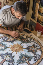 Jordan, Madaba, Handicraft Center Mosaic Workshop, A mosaicist at the Handicraft Center Mosaic Workshop places the pieces of tile for his mosaic piece in progress. All the mosaicists that work in the...