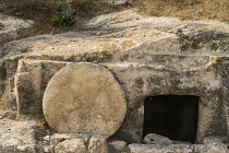 Israel, Galilee, A traditional 1st Century A.D. tomb with a rolling stone door in northern Israel. According to the Biblical description, Jesus of Nazareth was buried in a tomb much like this one.