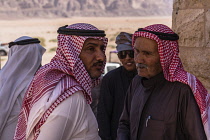 Jordan, Wadi Rum Protected Area, Bedouin men wearing the traditional keffiyeh or kufiiya (head scarf) and agal (rope headband) talking in the Wadi Rum Protected Area, a UNESCO World Heritage Site.