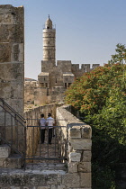 Israel, Jerusalem, Armenian Quarter, Two young Jewish boys wearing yarmulkes walk on the city wall of Jerusalem near the minaret of the Tower of David or the Citadel. The Old City of Jerusalem and its...