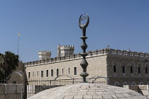 Israel, Jerusalem, The Muslim crescent on top of a small mosque in the Christian Quarter of the Old City. In the background is the Pontifical Institute of Notre Dame of Jerusalem. The Old City of Jeru...