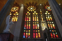 Spain, Catalonia, Barcelona, Interior of the Sagrada Familia designed by Antoni Gaudi, Nave, Passion side, Joan Vila-Grau designed stained glass .