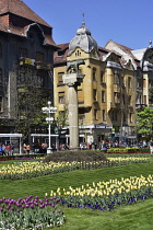 Romania, Timis, Timisoara, View through gardens of Piata Victoriei with statue of Romulus and Rebus, old town.