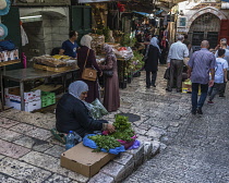 Israel, Jerusalem, A Palestinian Arab woman in tradtional dress sells produce in the street market by the Damascus Gate in the Muslim Quarter of the Old City. The Old City of Jerusalem and its Walls i...