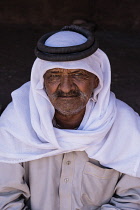 Jordan, Petra, A Bedouin man wearing a keffiyeh (head scarf) and agal (rope headband) in Petra in the Petra Archeological Park is a Jordanian National Park and a UNESCO World Heritage Site.